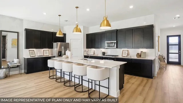 a living room with stainless steel appliances kitchen island granite countertop a table chairs and a sink