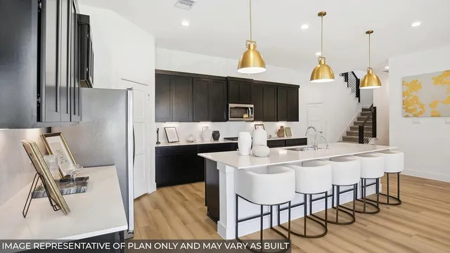 a kitchen with stainless steel appliances a dining table chairs and a refrigerator