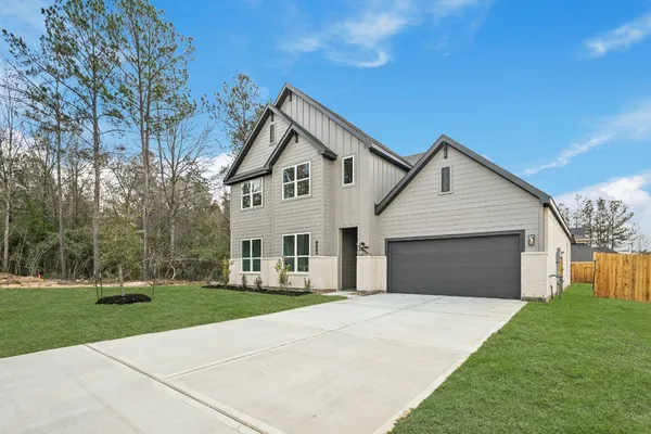 a front view of a house with a yard and trees