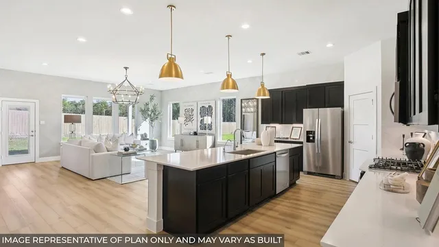 a large kitchen with stainless steel appliances kitchen island granite countertop a sink and cabinets