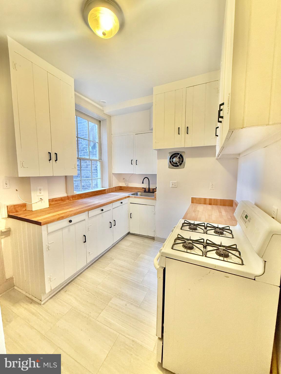 119 Prince Street, Unit 1 Alexandria, VA 22314 - Photo 7 of 29 a kitchen with sink a stove and cabinets