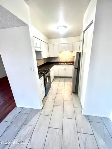 a kitchen with a refrigerator and a stove top oven