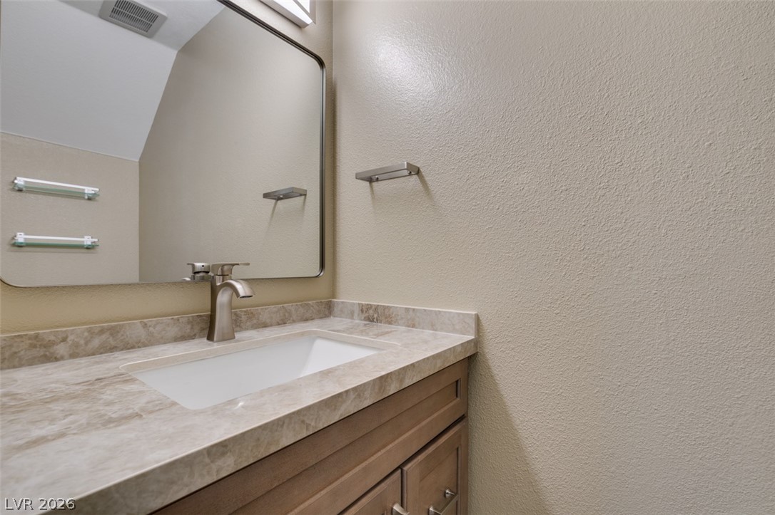 540 Sutters Mill Road Henderson, NV 89014 - Photo 33 of 46 This bathroom features a contemporary vanity with a sleek faucet and elegant countertop.