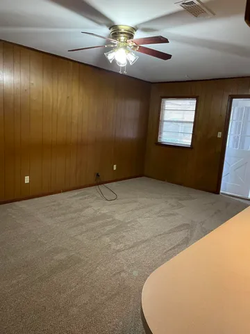 en empty room with windows and fan