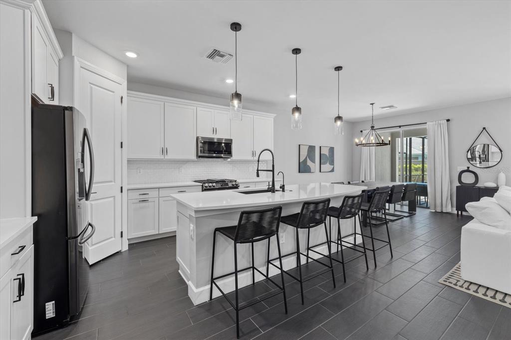 3508 Anchor Bay Trail Lakewood Ranch, FL 34211 - Photo 8 of 74 a large kitchen with cabinets chairs and refrigerator