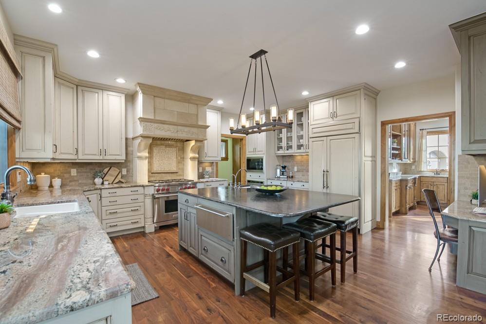 6570 Rookery Road Fort Collins, CO 80528 - Photo 15 of 40 a kitchen with stainless steel appliances a dining table chairs stove and white cabinets