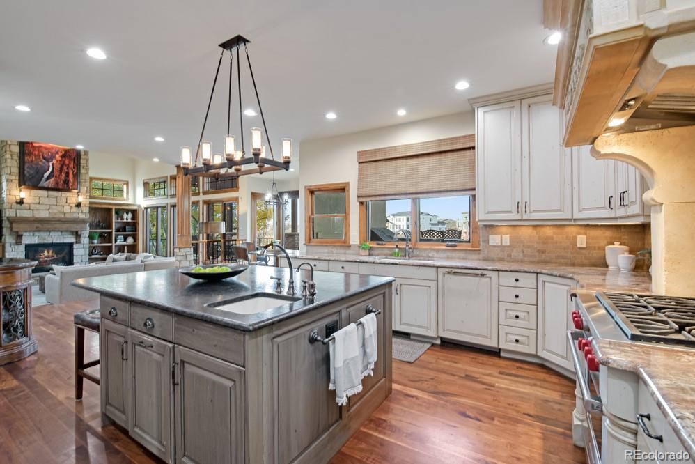 6570 Rookery Road Fort Collins, CO 80528 - Photo 17 of 40 a kitchen with stainless steel appliances granite countertop a sink a stove and a wooden floors