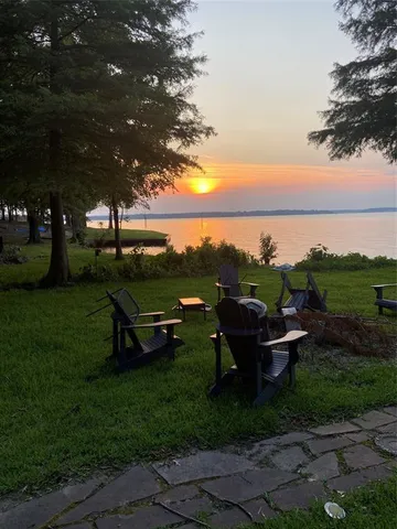 a view of a garden with lawn chairs and a fire pit