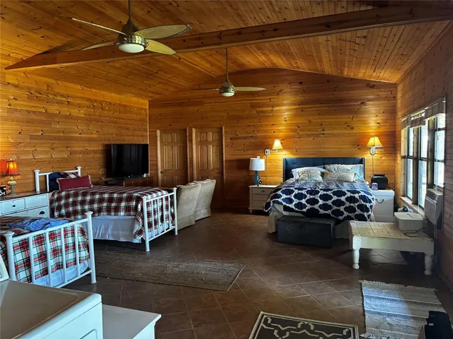 a bedroom with furniture and a flat screen tv