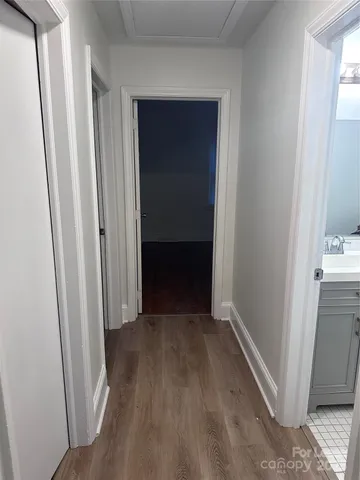 a view of a hallway with wooden floor and closet
