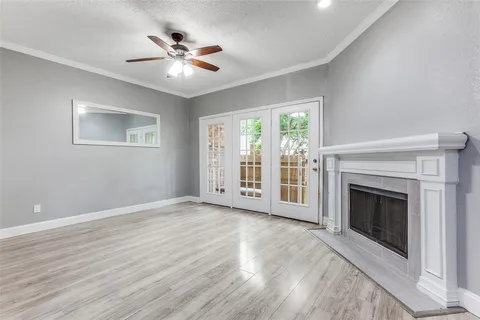 wooden floor fireplace and windows in an empty room