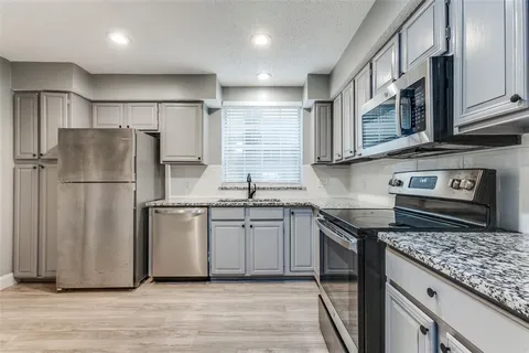 a kitchen with stainless steel appliances granite countertop a refrigerator stove and sink