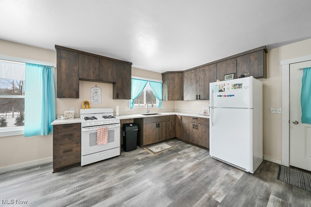 10622 Reynolds Road West Farmington, OH 44491 - Photo 2 of 32 Kitchen featuring white appliances, dark brown cabinetry, and sink