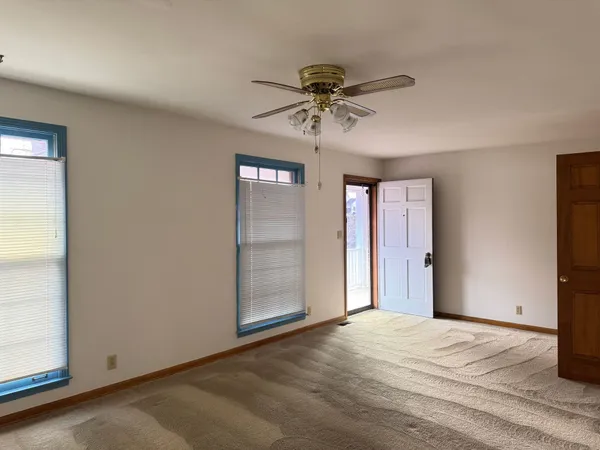a view of a livingroom with a chandelier fan and windows