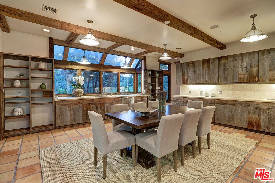 10960 Bellagio Road Los Angeles, CA 90077 - Photo 9 of 22 a dining room with stainless steel appliances kitchen island granite countertop a table chairs and a view of living room