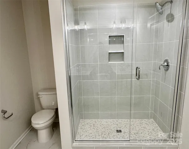 a bathroom with a toilet and a shower