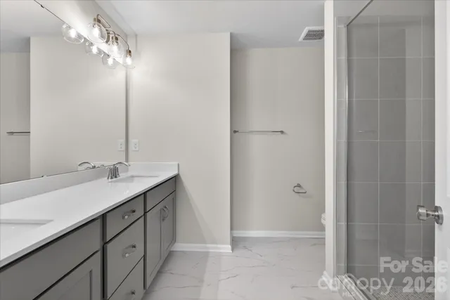 a bathroom with a double vanity sink mirror and shower