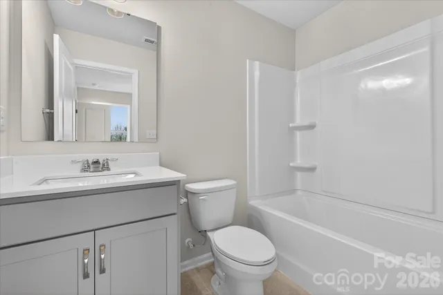 a bathroom with a sink toilet vanity and tub