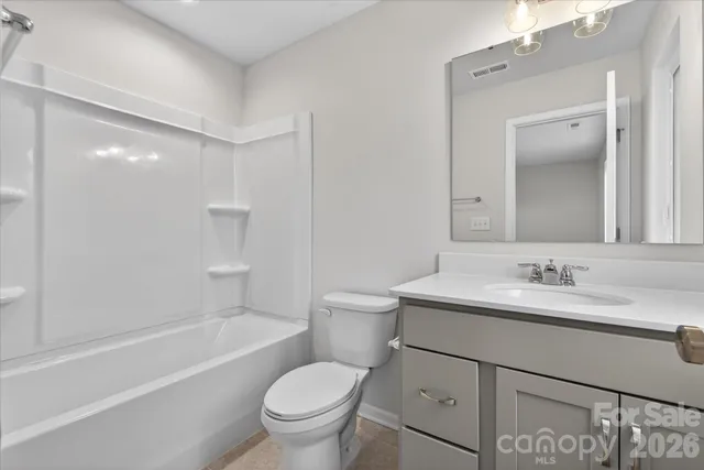 a bathroom with a sink toilet vanity and tub