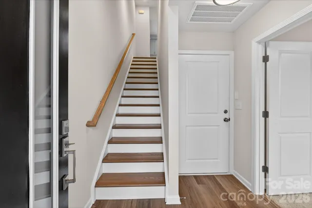 a view of a hallway with wooden floor and entryway