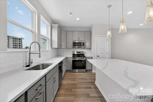 a kitchen with kitchen island granite countertop a sink stainless steel appliances and cabinets