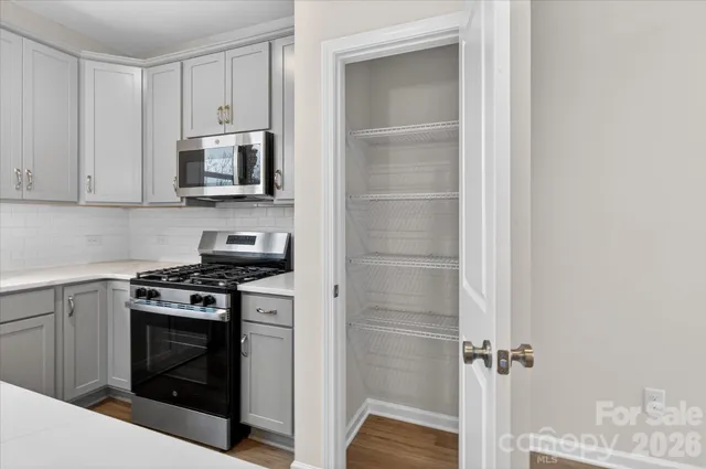 a kitchen with white cabinets and stainless steel appliances