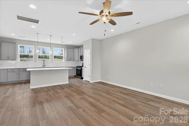 a large kitchen with a wooden floor and stainless steel appliances