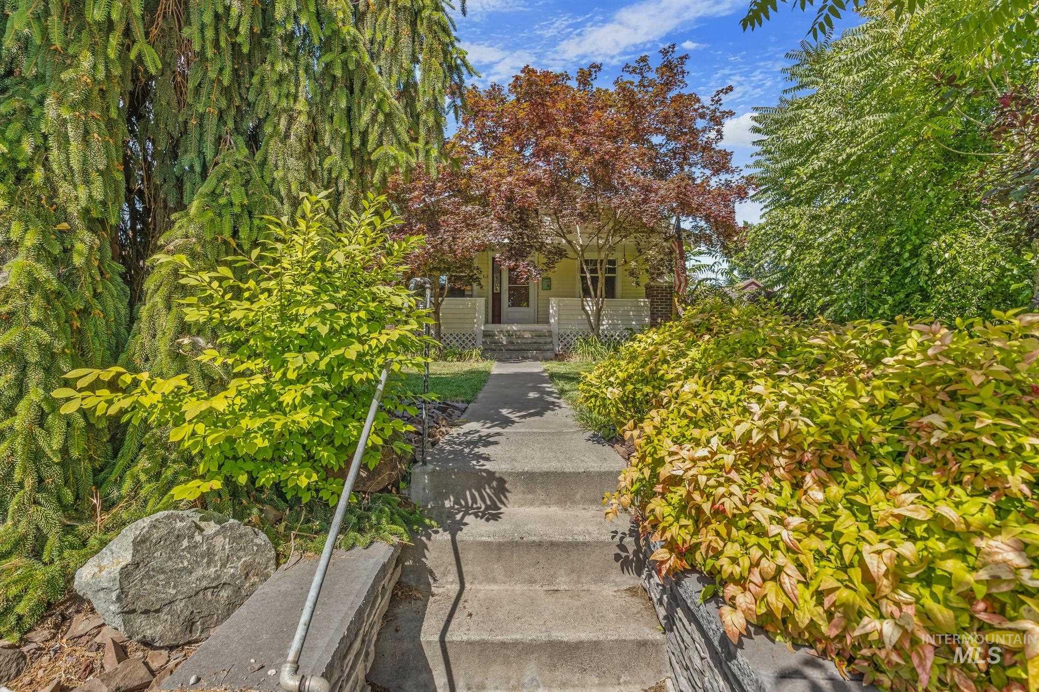 928 3rd Street Clarkston, WA 99403 - Photo 5 of 44 Path to the home features mature landscaping, a concrete walkway, and stone retaining walls
