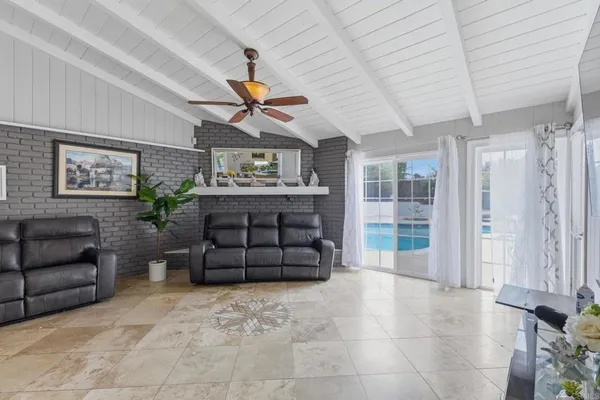 a living room with furniture a ceiling fan and a rug