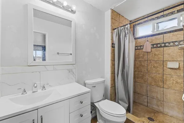 a bathroom with a sink a toilet and shower