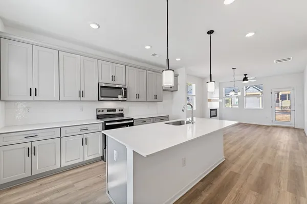a large kitchen with cabinets wooden floor and stainless steel appliances