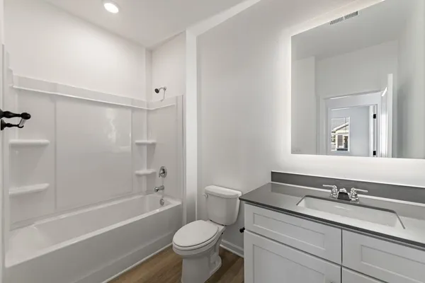 a bathroom with a granite countertop toilet a sink and a bathtub