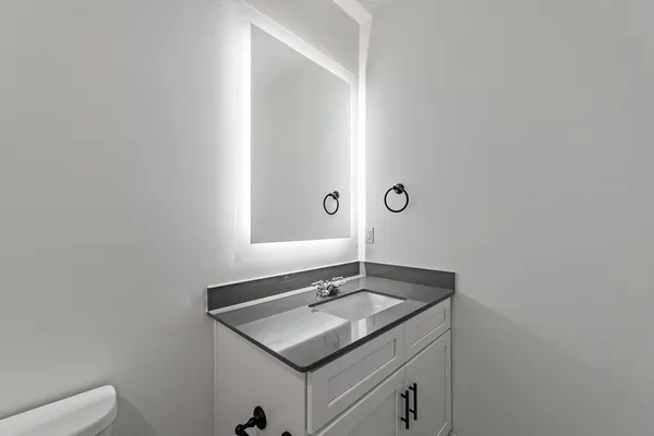 a bathroom with a granite countertop sink and a mirror
