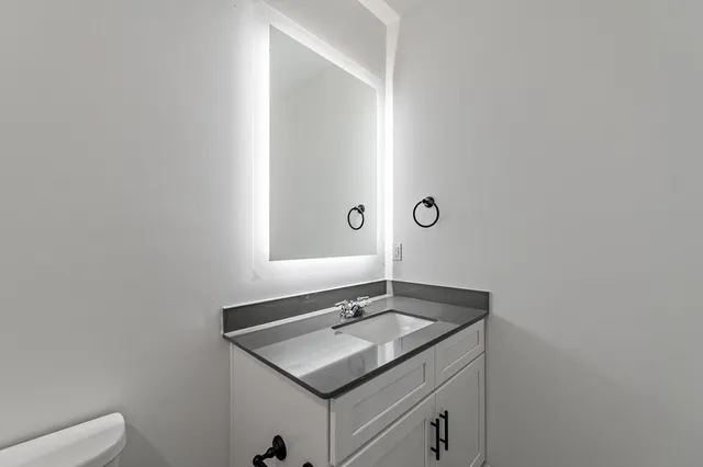 a bathroom with a granite countertop sink and a mirror