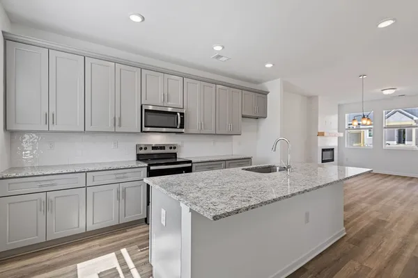 a kitchen with granite countertop white cabinets and a stainless steel appliances