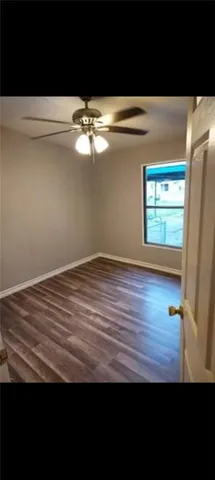 a view of empty room with window and wooden floor
