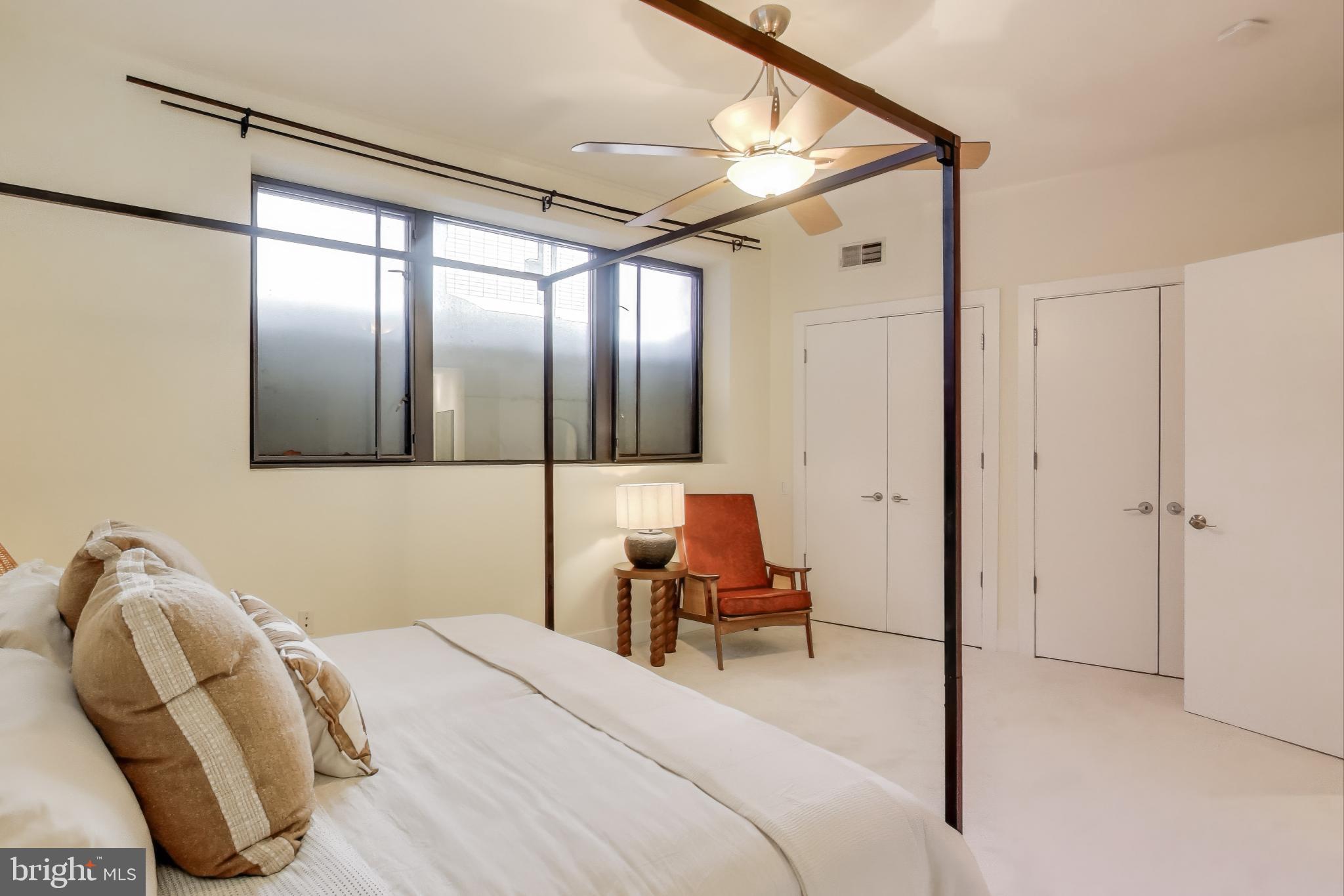 2426 Ontario Road Northwest, Unit 101 Washington, DC 20009 - Photo 10 of 22 a bedroom with a bed chair and the mirror