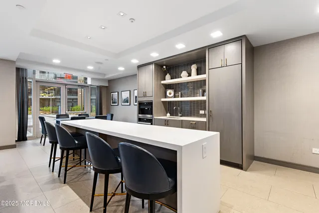 a kitchen with stainless steel appliances kitchen island a table and chairs