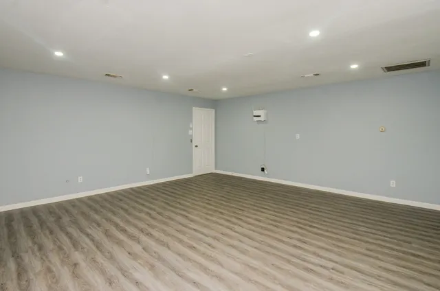 an empty room with wooden floor and entrance