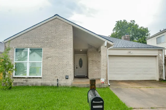 a front view of a house with a garden and yard
