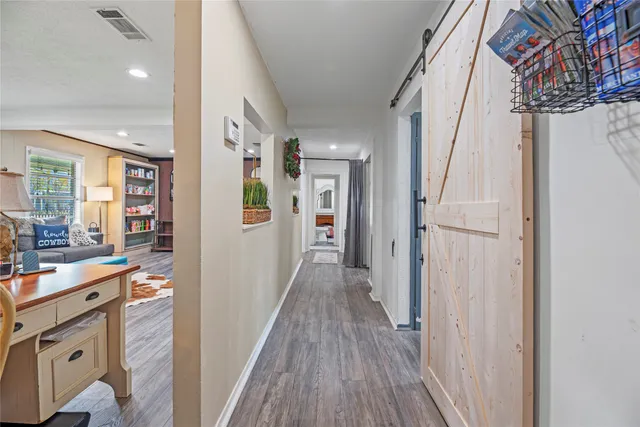 a view of a hallway with wooden floor and staircase