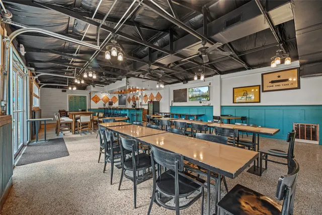 a room with stainless steel appliances kitchen island a table and chairs