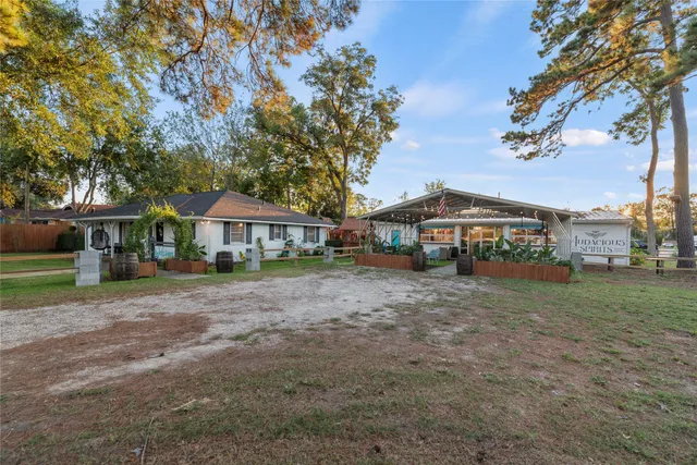 a front view of a house with a garden and trees
