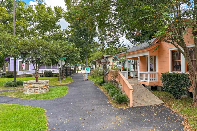 a view of a house with large tree and wooden deck