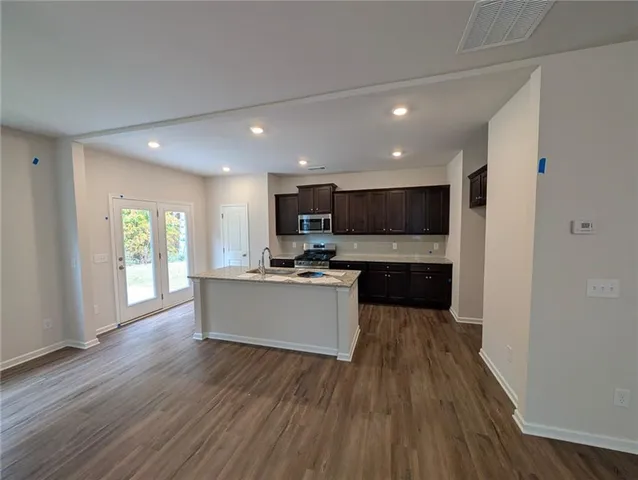 a large kitchen with a lot of counter space and stainless steel appliances