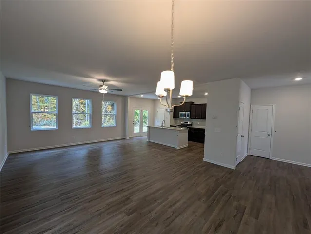 a view of a kitchen with a sink dishwasher a kitchen counter top and wooden floor