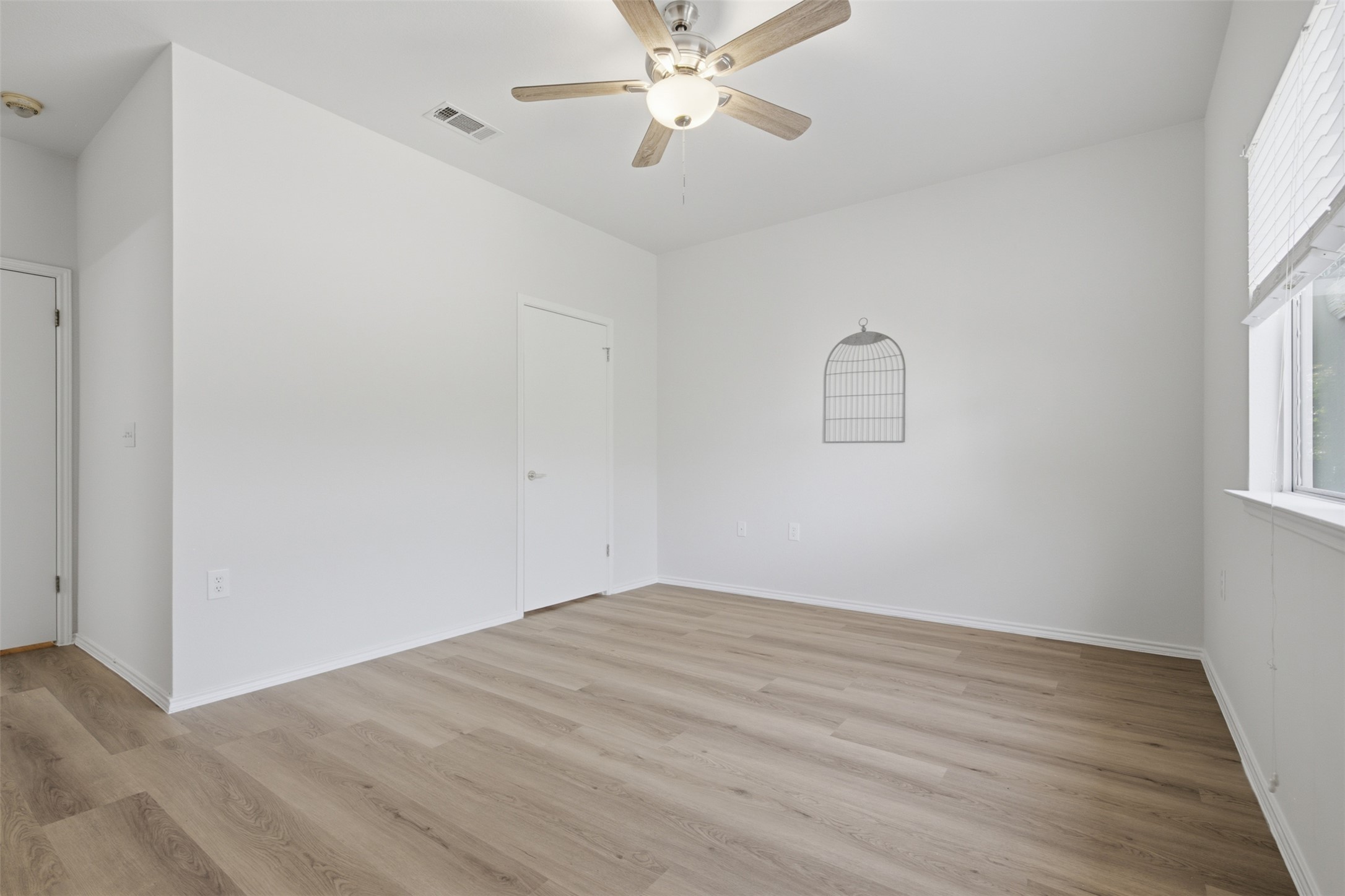 126 Whitewing Way Georgetown, TX 78633 - Photo 12 of 28 A quiet bedroom featuring light wood flooring and a modern ceiling fan for comfortable living.
