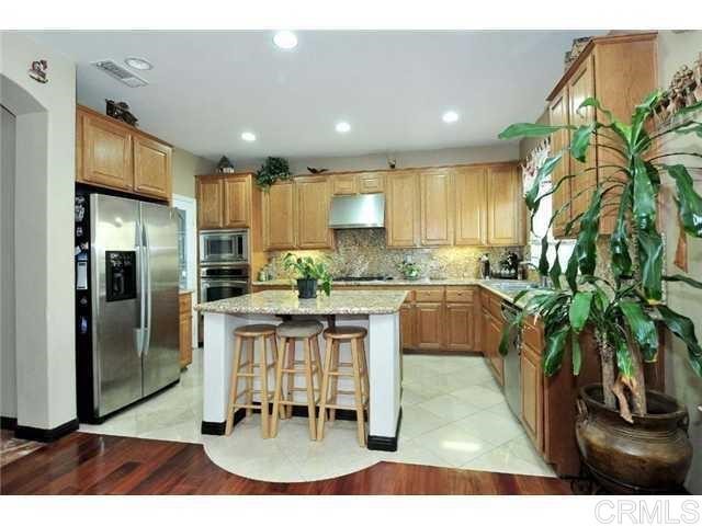 310 Corte Goleta Chula Vista, CA 91914 - Photo 3 of 6 a kitchen with granite countertop a refrigerator a stove a sink and a dining table