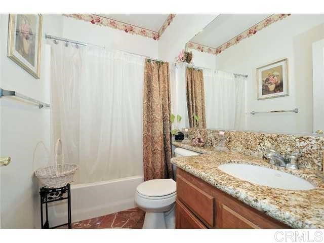 310 Corte Goleta Chula Vista, CA 91914 - Photo 5 of 6 a bathroom with a granite countertop sink toilet a mirror and shower