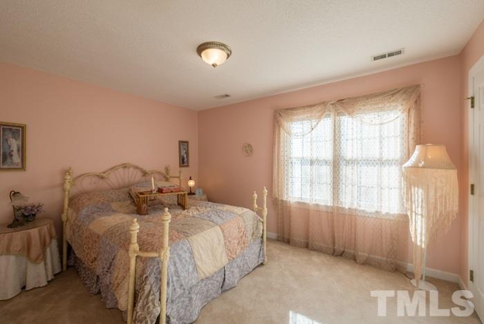 5624 Barham Court Raleigh, NC 27613 - Photo 12 of 19 a bed sitting in a spacious bedroom next to a window